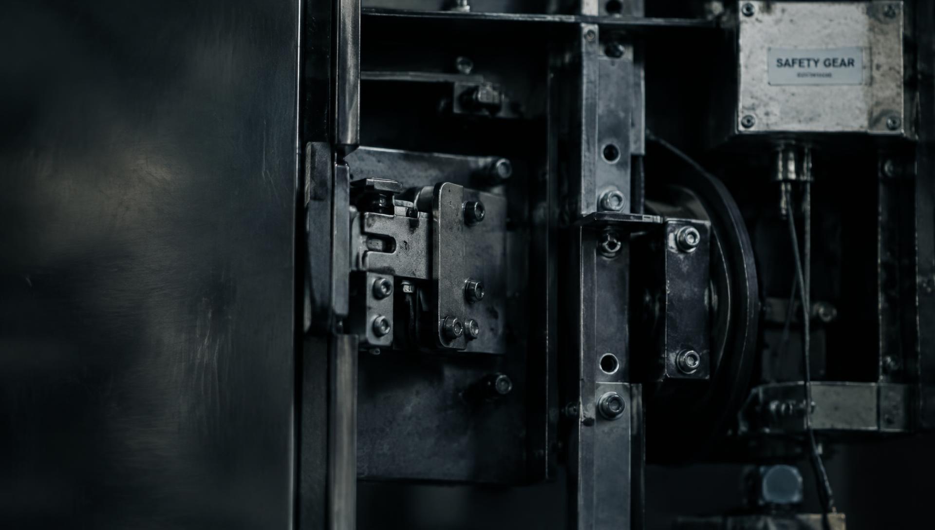 Close-up of an elevator door interlock and safety gear mechanism
